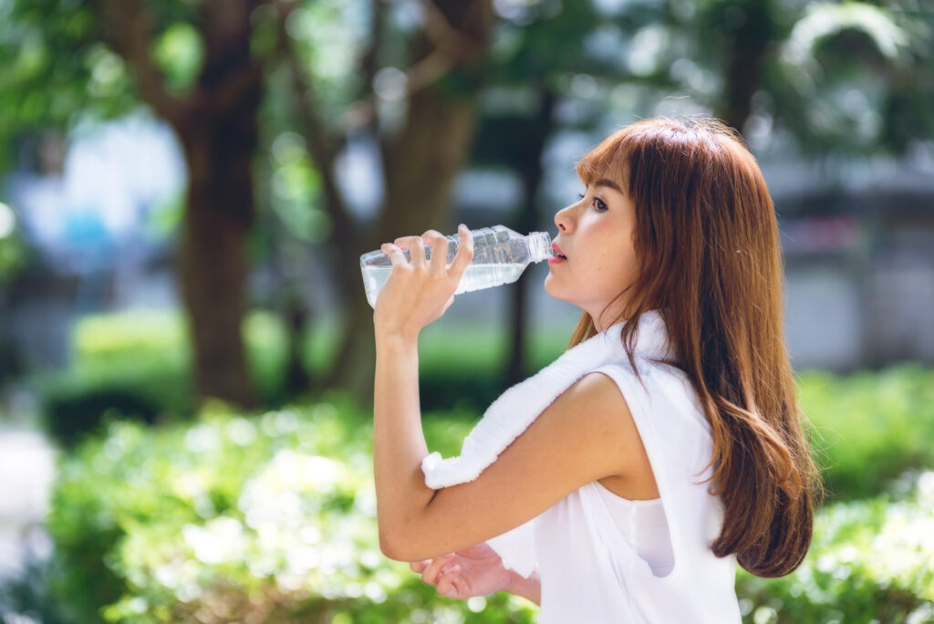 Portrait of beautiful teen woman resting after jogging at the pa